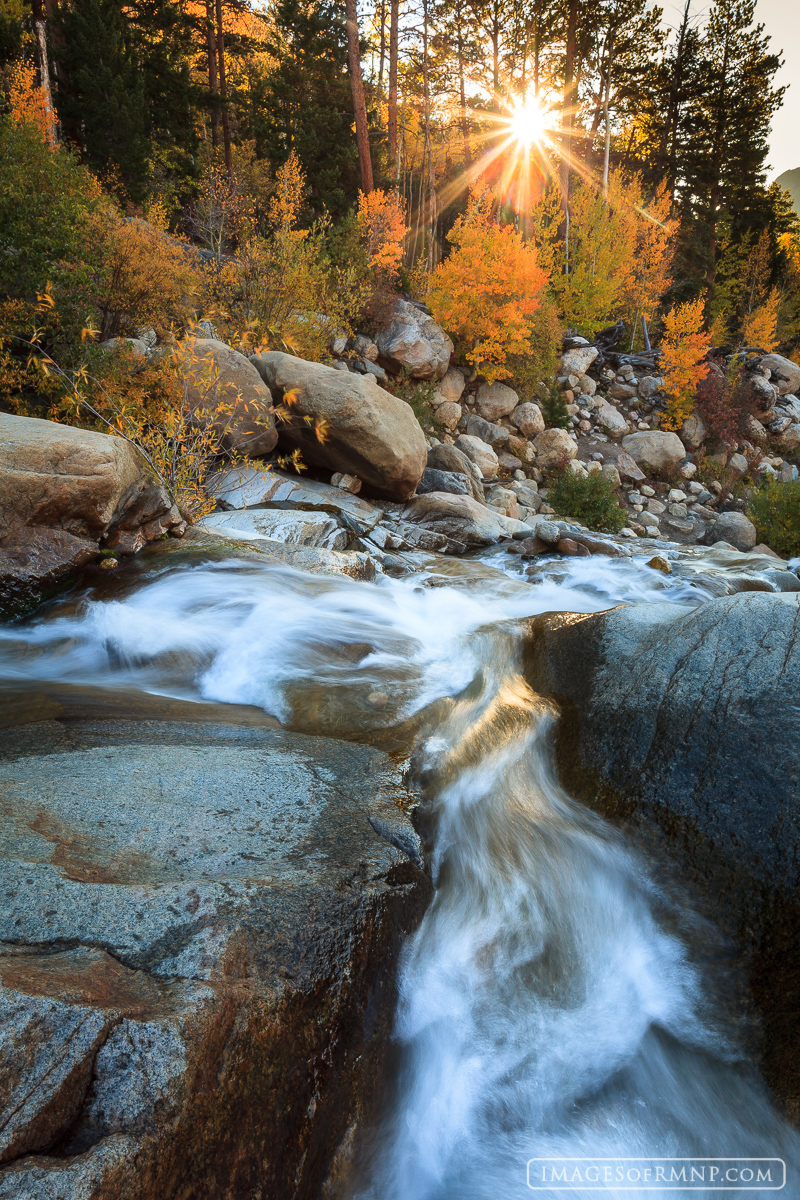 On a beautiful October morning following a season of unseasonably warm weather, the rising sun breaks through the colorful aspen...