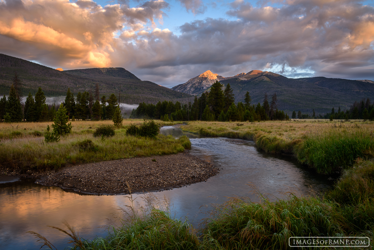 The sun rises in the Kawuneeche Valley on the west side of Rocky Mountain National Park illuminating Baker Mountain while the...