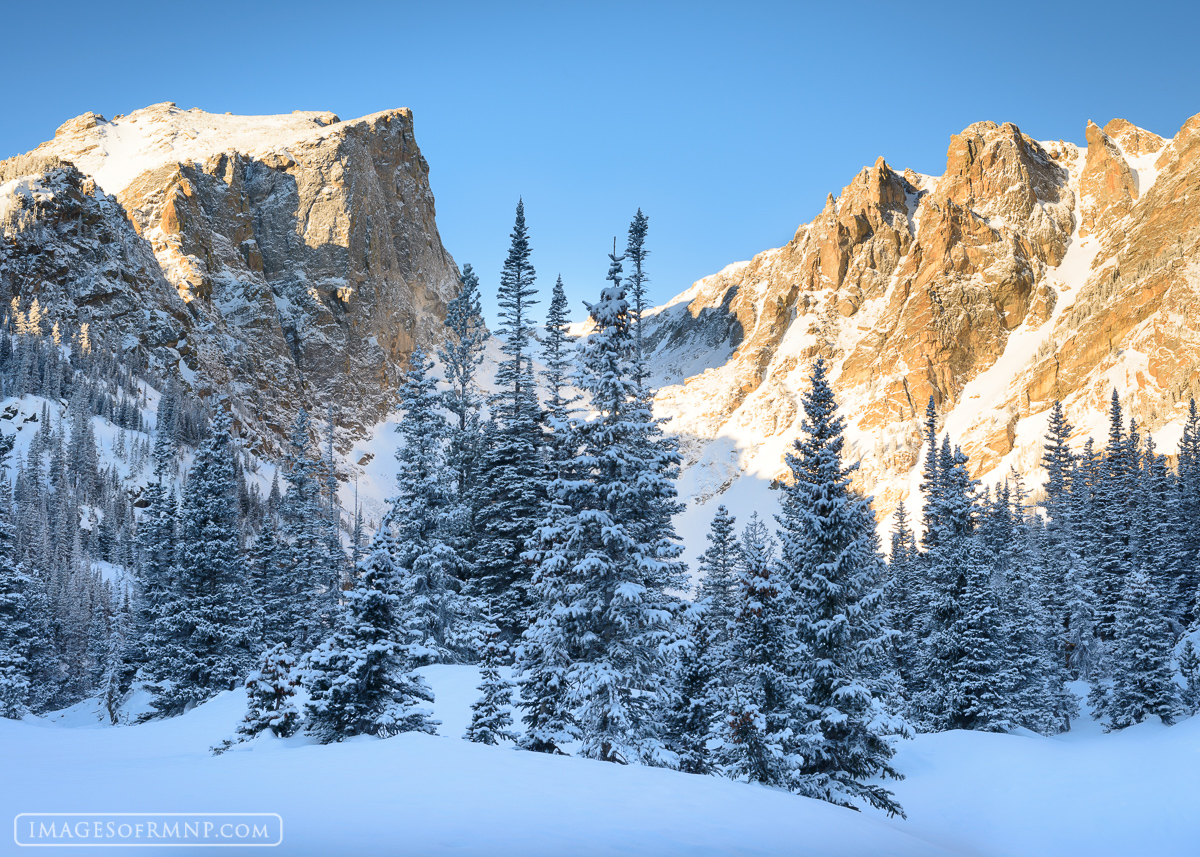 Following a winter storm, Hallett Peak and Flattop Mountain awaken to a world fresh with snow while calm bluebird skies smile...