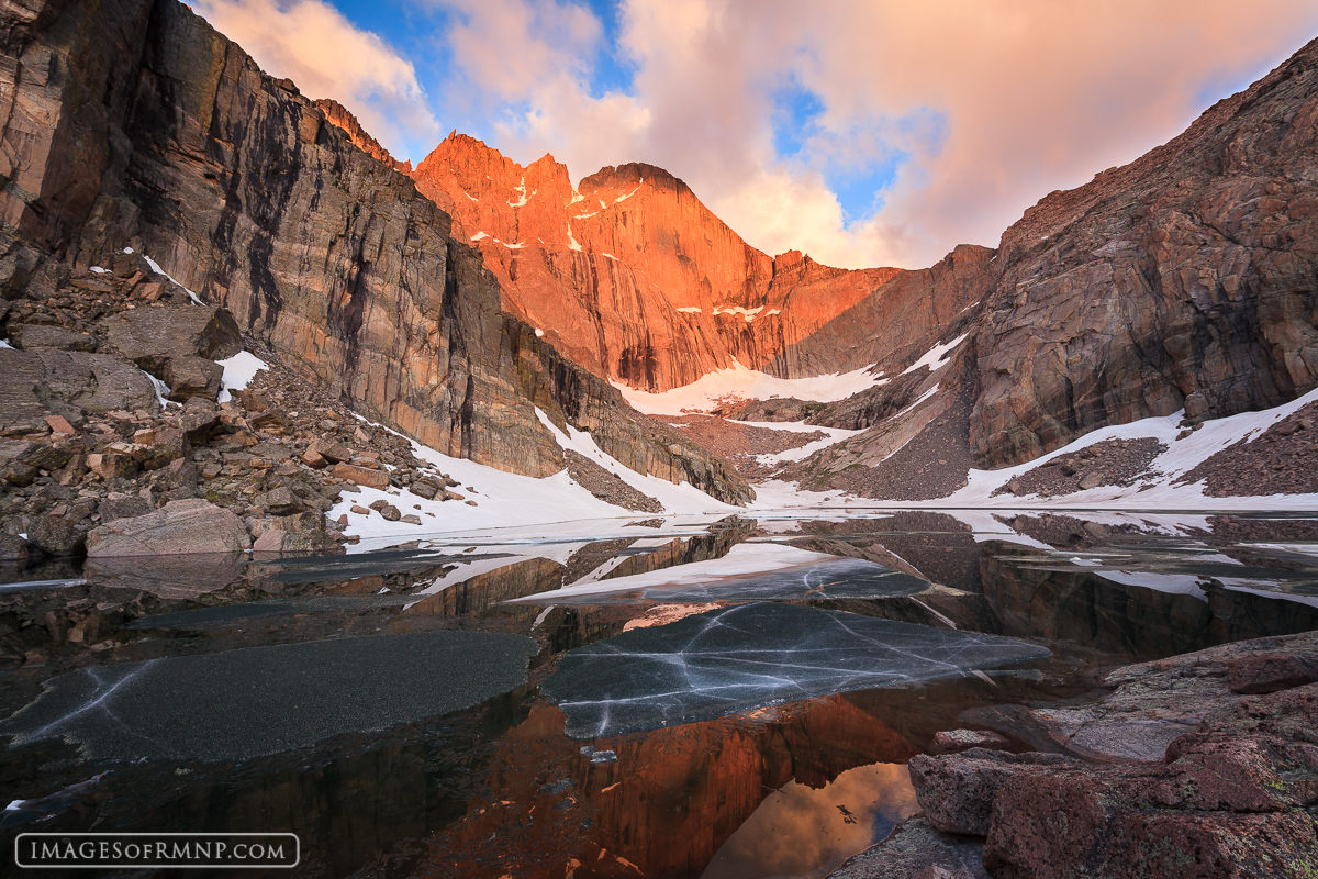 Sheets of ice float across Chasm Lake as the morning light illuminates Longs Peak on a beautiful July morning.