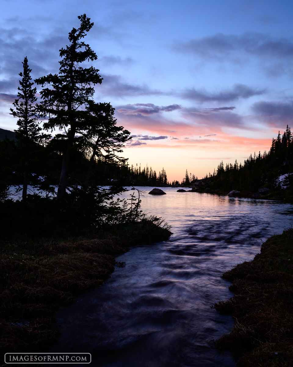A new day begins deep in the backcountry of Rocky Mountain National Park beside a high country lake. As the sky begins to lighten...
