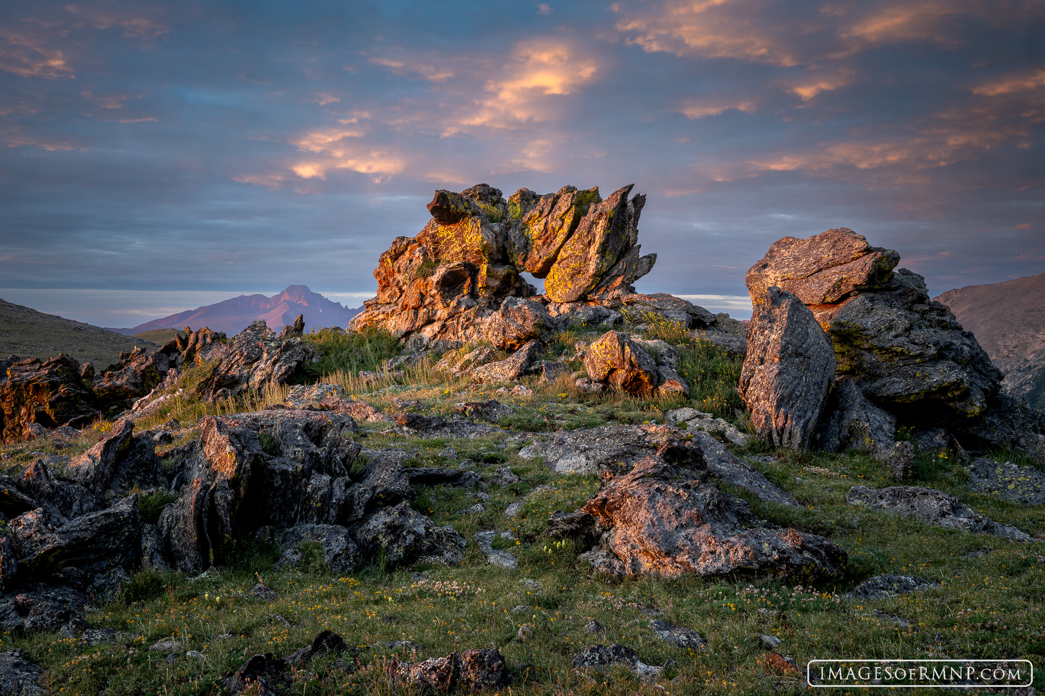 High in the tundra of Rocky Mountain National Park, the rising sun briefly breaks through the clouds and illuminates rocks on...