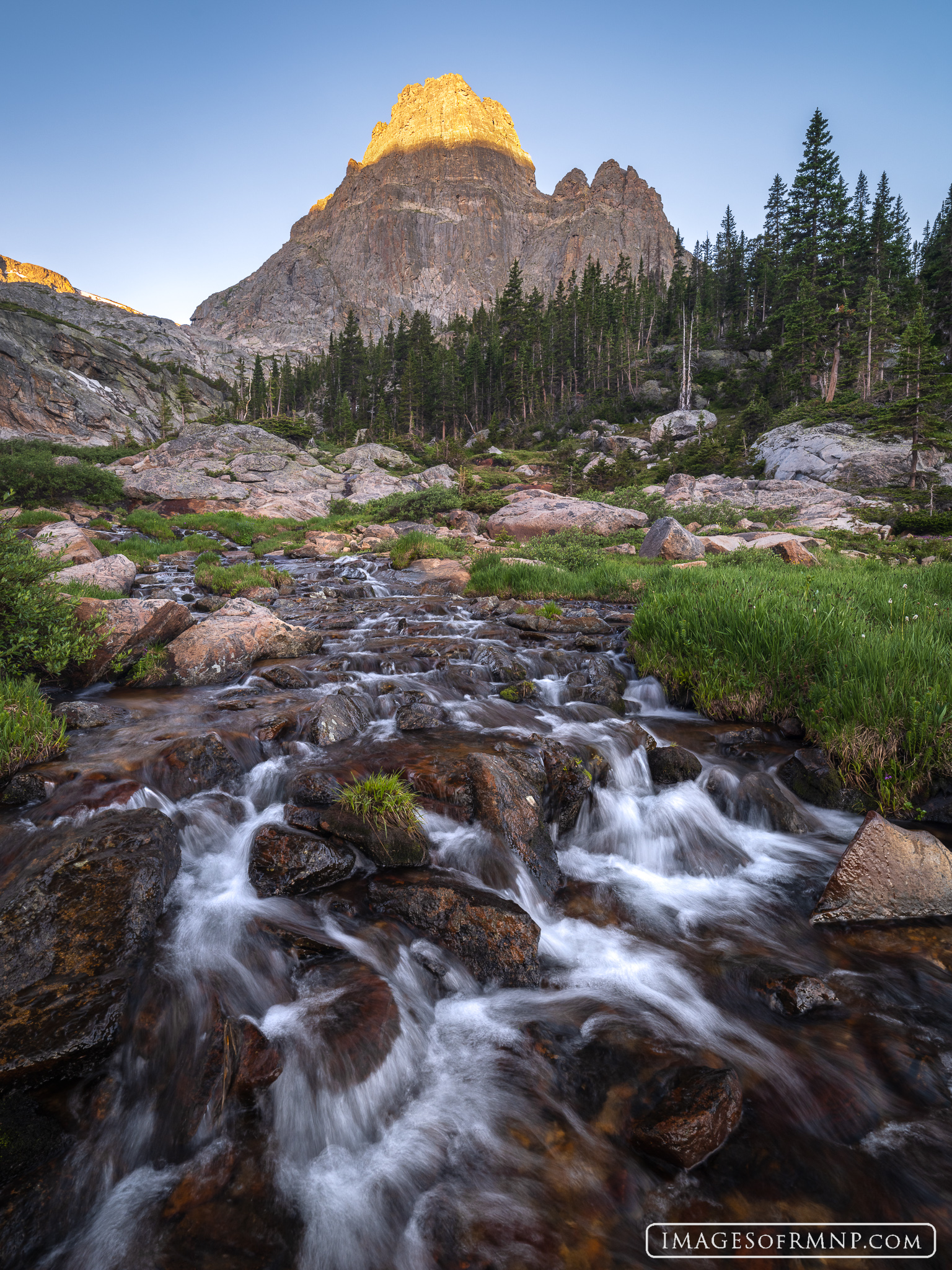 A jagged peak awakens in a remote valley in Rocky Mountain National Park. As you view this image, hear the sound of the rushing...