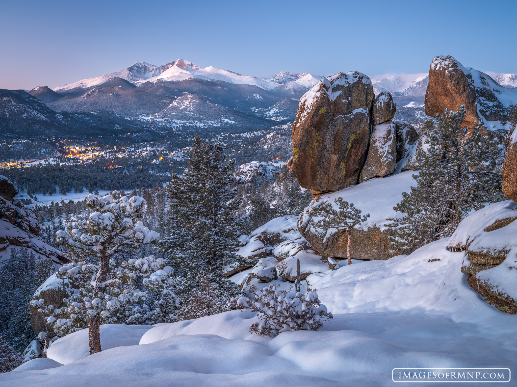 The previous night’s winter storm blanketed the earth with fresh snow. As this new day dawns, the lights of Estes Park, Colorado...