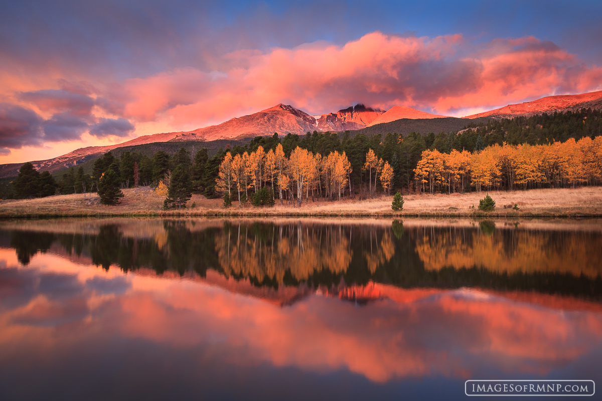 On a perfect autumn morning the warm light of the rising sun bathes Mount Meeker and Longs Peak in its gentle pink hues as they...