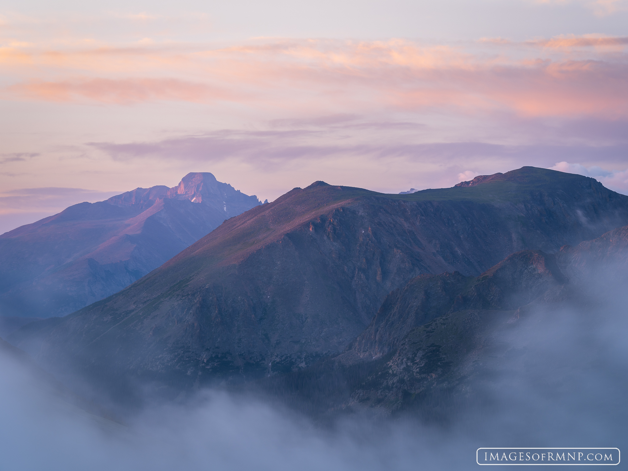 Longs Peak with its unusual flat top and Stones Peak with its double summit seem to float above the clouds at dawn on a July...