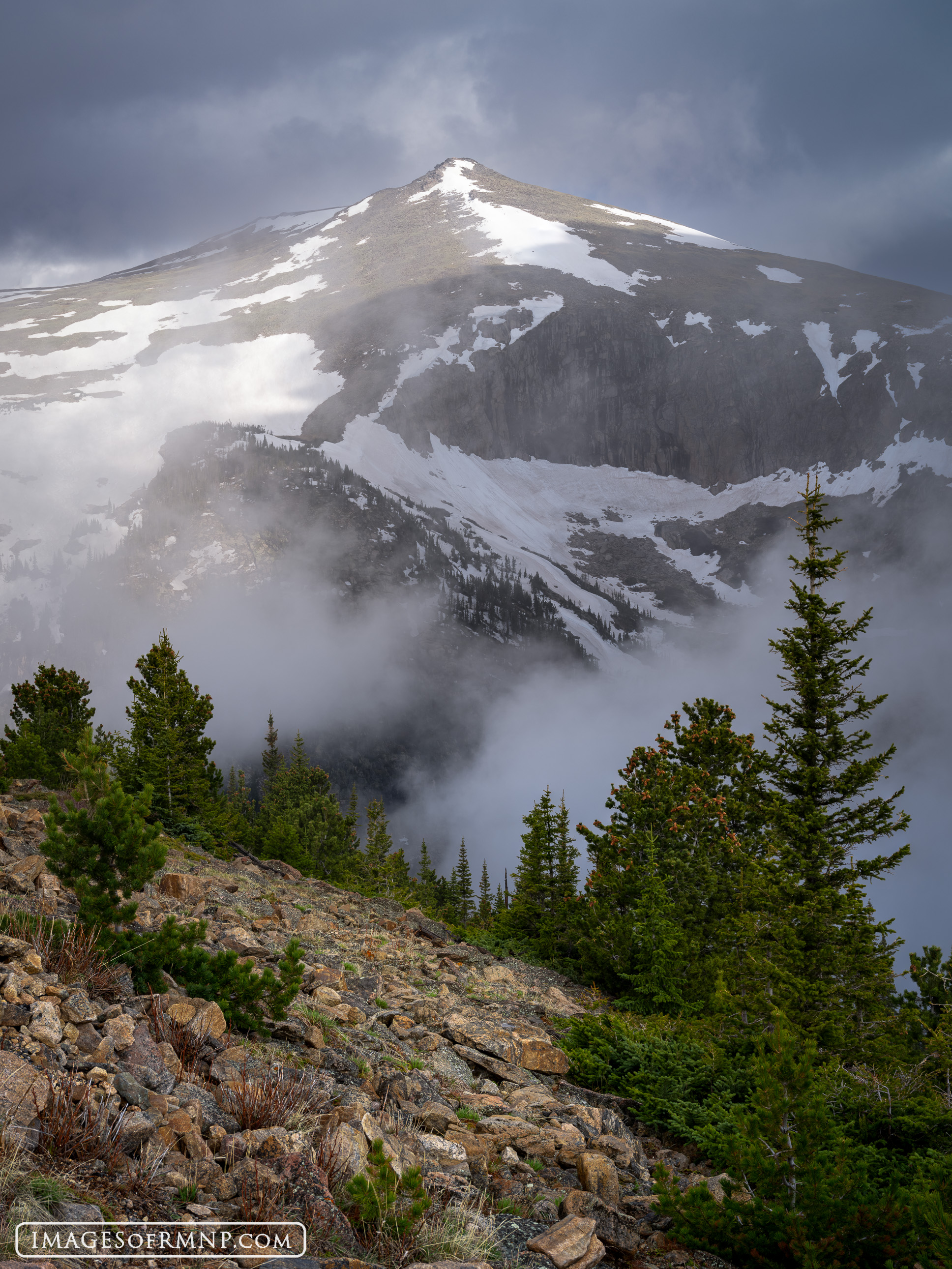 Storm clouds move through the mountains sneaking up valleys before swallowing mountains. Yet the sun dances on the peaks before...