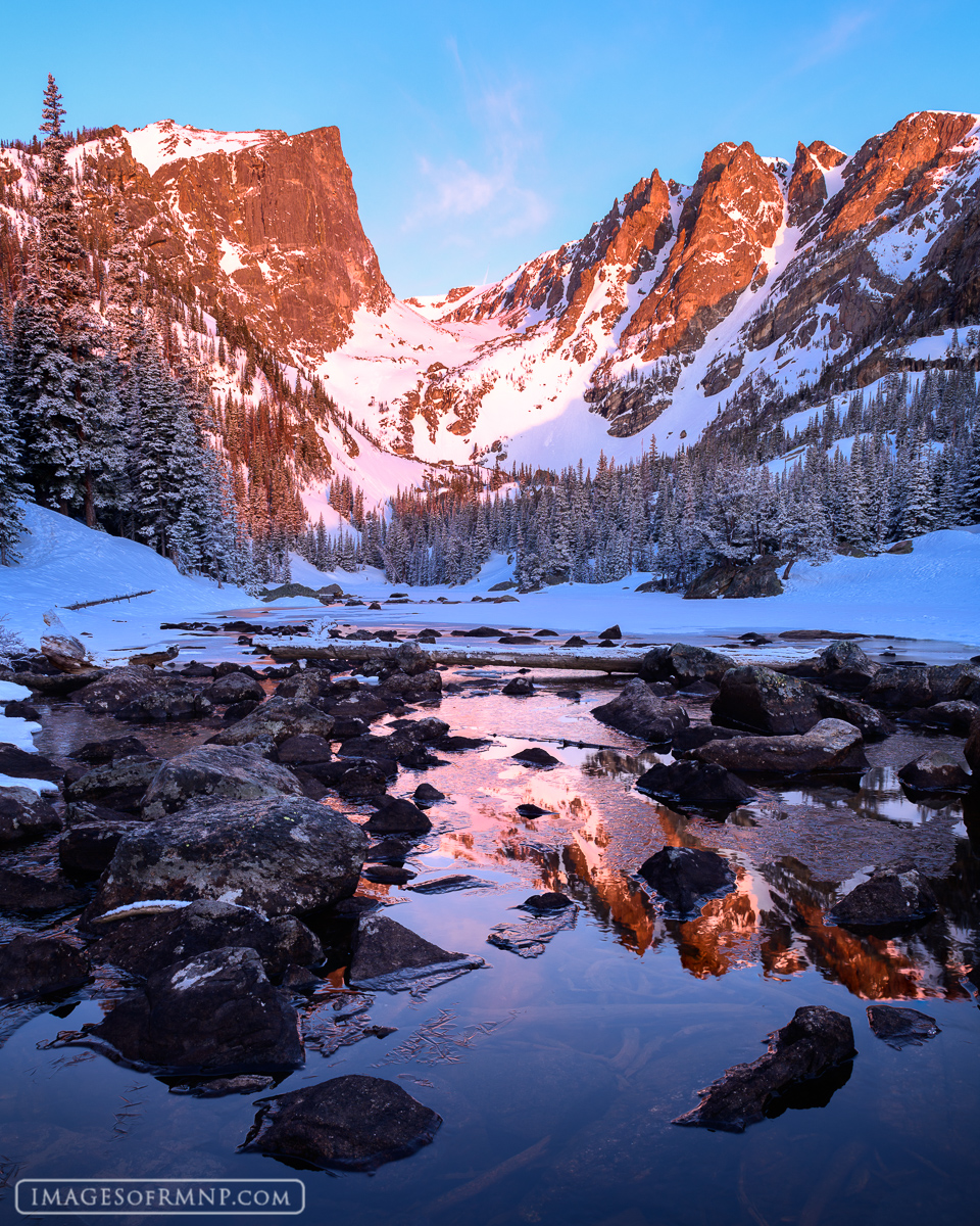 Spring arrives at Dream Lake in Rocky Mountain National Park with melting ice and fresh snow.