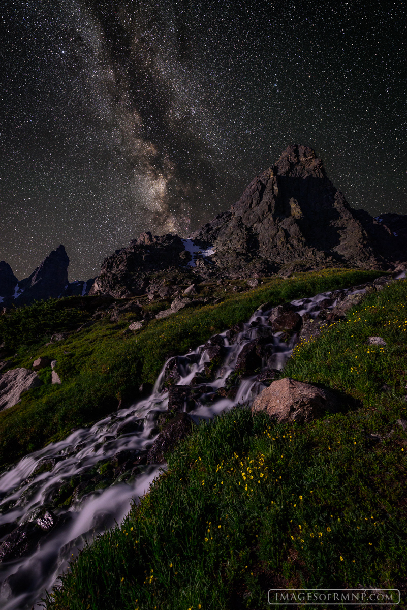 The rising moon gently illuminates the peaks and tundra grasses on a crystal clear night in the backcountry of Rocky Mountain...